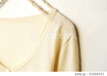 白バックとハンガーにかけた白のカーディガンの肩や襟のクローズアップ 61600452