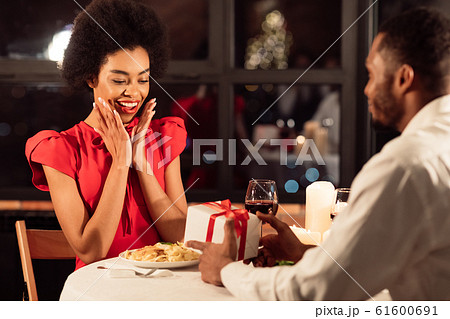 Boyfriend Giving Valentine Present To Girlfriend During Date In Restaurant Boyfriend Giving Valentine Present To Girlfriend During Date In Restaurant 61600691