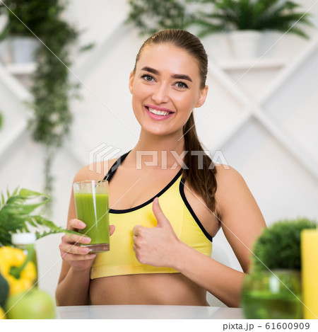 Healthy drink. Girl holding smoothie and showing thumb up Healthy drink. Girl holding smoothie and showing thumb up 61600909