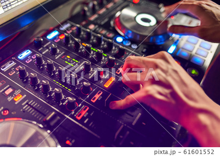 Dj mixes the track in the nightclub at party. In the background laser light show Dj mixes the track in the nightclub at party. In the background laser light show 61601552