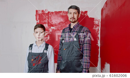 A little boy and his father standing in the room - painting walls 61602006
