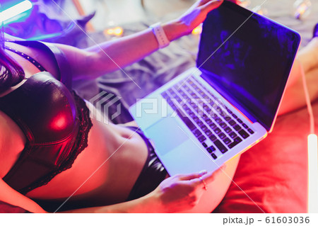 Beautiful, young girl posing in front of a web camera, working as a model. The concept of online flirting. 61603036