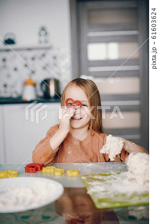 Little girl cook the dough for cookies Little girl cook the dough for cookies 61603624