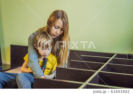 Mother and son assembling furniture. Boy helping his mom at home. Happy Family concept Mother and son assembling furniture. Boy helping his mom at home. Happy Family concept 61603882
