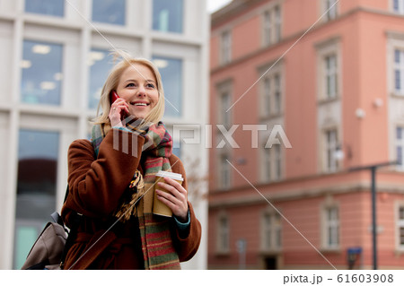 woman with cup of coffee talking by mobile phone woman with cup of coffee talking by mobile phone 61603908