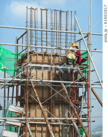 Construction workers fabricating column timber form work and reinforcement bar at the construction site in Malacca, Malaysia.  61603917
