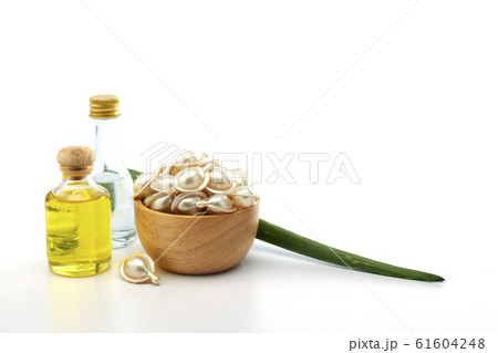 Hair treatment capsule in wooden bowl on white 61604248