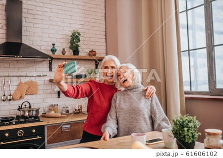 Two energetic grey-haired positive ladies looking happy Two energetic grey-haired positive ladies looking happy 61606102