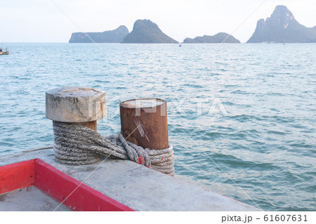 Steel pillar in the sea Is tied with a concrete post with a rope Steel pillar in the sea Is tied with a concrete post with a rope 61607631