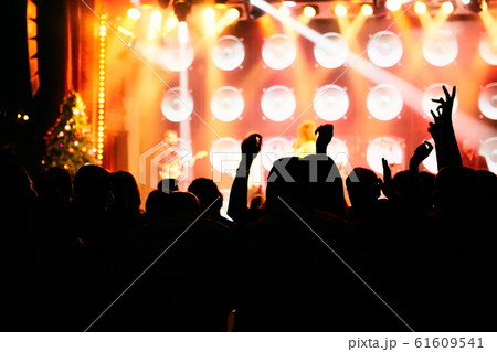 silhouettes of concert crowd in front of bright stage lights 61609541