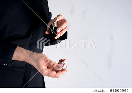 Woman spraying perfume on her wrist. Focus on hands and perfume bottle. Copy space Woman spraying perfume on her wrist. Focus on hands and perfume bottle. Copy space 61609942