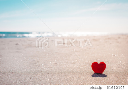 Romantic symbol of red heart on the sand beach 61610105