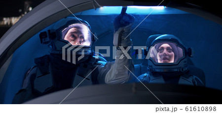 Astronaut looking out of spaceship window 61610898