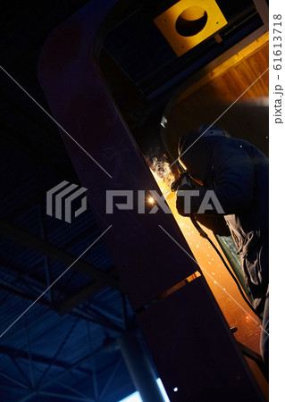 welder working with electrode at semi-automatic arc welding in manufacture production plant.Selective focus welder working with electrode at semi-automatic arc welding in manufacture production plant.Selective focus 61613718