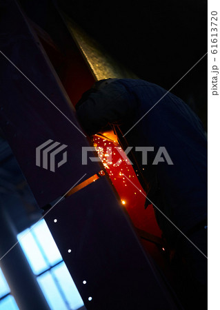 welder working with electrode at semi-automatic arc welding in manufacture production plant.Selective focus welder working with electrode at semi-automatic arc welding in manufacture production plant.Selective focus 61613720