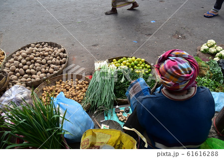インドのコルカタの市場 種類豊富で新鮮な野菜を販売する八百屋 秤を使い仕事をするインド人店主の写真素材