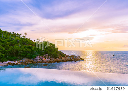 Beautiful outdoor infinity swimming pool in hotel resort with sea ocean view and white cloud blue sky 61617989