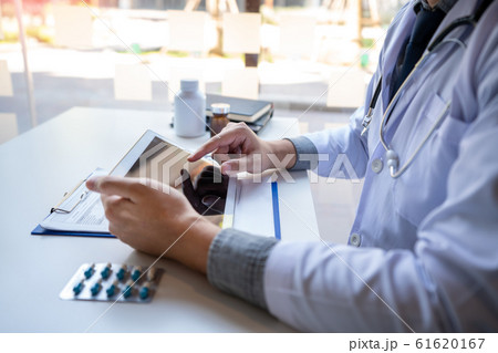 Doctor reading on a document report and writing on 61620167