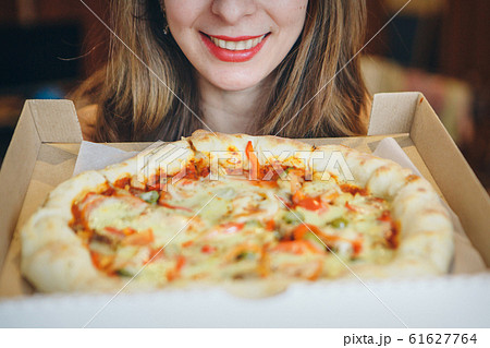 Portrait of a happy girl with a pizza in her hands. fast food advertising, confectionery, cooking, overeating, diet, Italian food Portrait of a happy girl with a pizza in her hands. fast food advertising, confectionery, cooking, overeating, diet, Italian food 61627764