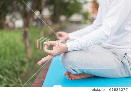 a man practicing yoga and meditation on blue mat near lagoon. health concept. 61628077