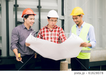 engineer and foreman team looking in blueprint for checking construction progress in construction site. 61628078