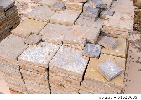 Laying paving slabs in pile on sidewalk in city park. 61628689