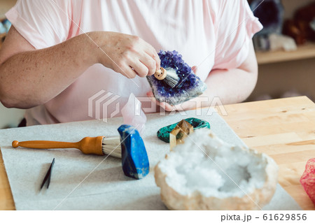 Woman brushing an amethyst 61629856
