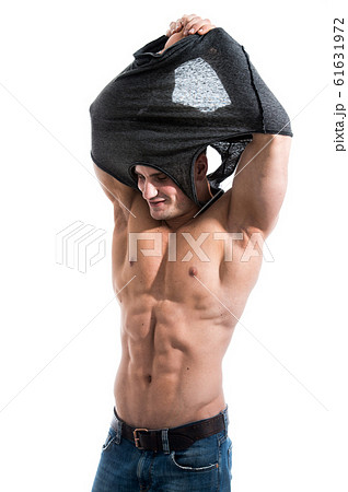 Awesome muscular man putting out his shirt. Isolated on white background. Awesome muscular man putting out his shirt. Isolated on white background. 61631972