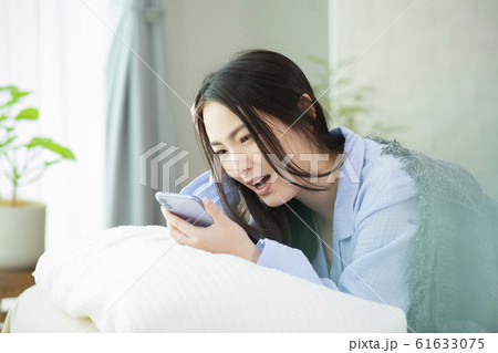 女性 寝坊 パジャマ ベッド 寝起き スマホ スマートフォン 女性 寝坊 パジャマ ベッド 寝起き スマホ スマートフォン 61633075