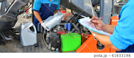 Mechanic adding Engine oil for quality into the engine motor car Transmission and Maintenance Gear.Energy fuel concept. 61633198