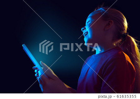 Caucasian girl's portrait isolated on dark studio background in neon light 61635355