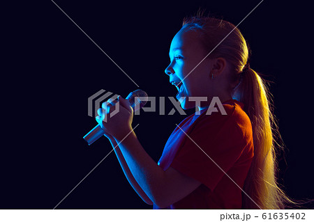 Caucasian girl's portrait isolated on dark studio background in neon light 61635402