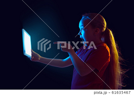 Caucasian girl's portrait isolated on dark studio background in neon light Caucasian girl's portrait isolated on dark studio background in neon light 61635467