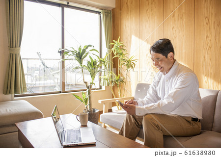 リビングでスマホでネットを見るミドル〜シニア男性 リビングでスマホでネットを見るミドル〜シニア男性 61638980