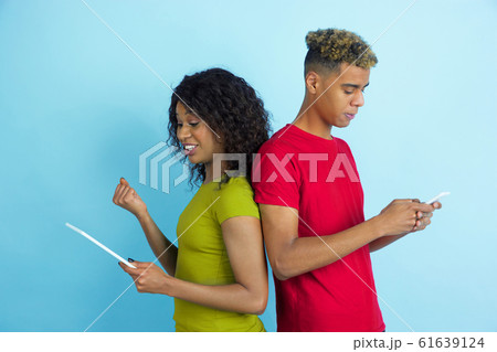 Young emotional african-american man and woman on blue background Young emotional african-american man and woman on blue background 61639124