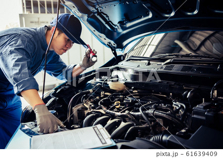Car mechanic technician holding flashlight Car mechanic technician holding flashlight 61639409