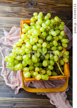 Picture from above of green grapes in wooden box with pink cloth Picture from above of green grapes in wooden box with pink cloth 61640133