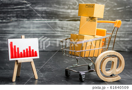 Shopping cart loaded with boxes, email symbol and red negative trend chart. Reduced online sales over the Internet. Fall in purchasing power. Price reduction. Decline in sales and business activity Shopping cart loaded with boxes, email symbol and red negative trend chart. Reduced online sales over the Internet. Fall in purchasing power. Price reduction. Decline in sales and business activity 61640509