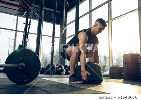 The male athlete training hard in the gym. Fitness and healthy life concept. 61640656