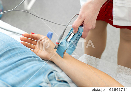 The doctor attaches the electrodes of the ECG pegs 61641714