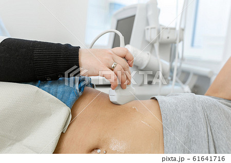 Close-up doctor conducts ultrasound diagnostics of 61641716