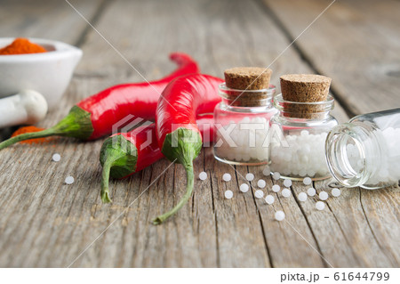 Chili peppers and bottles of homeopathic globules 61644799