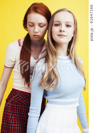 lifestyle people concept: two pretty young school teenage girls having fun happy smiling on yellow background 61647166