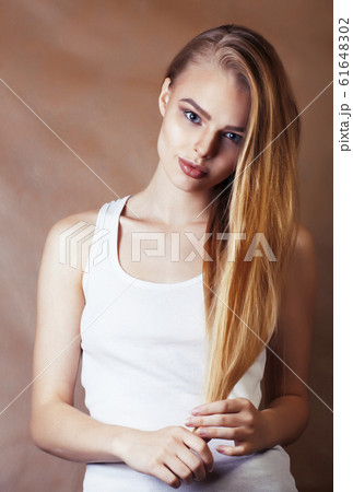 young pretty blond woman with fresh natural makeup posing cheerful on browm background, lifestyle people concept young pretty blond woman with fresh natural makeup posing cheerful on browm background, lifestyle people concept 61648302