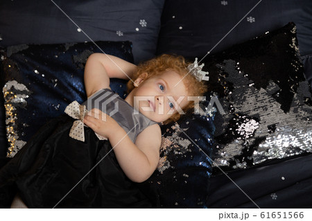 Beautiful little girl child on a New Year's bed. 61651566
