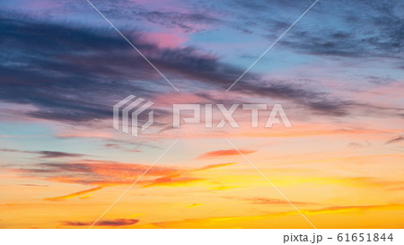 Evening sunset sky with bright rays of the sun and beautiful colorful clouds 61651844