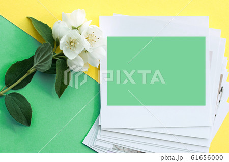 printed photos, frame cards, on a turquoise background with a white jasmine flower. Mock up. copy space. place for text printed photos, frame cards, on a turquoise background with a white jasmine flower. Mock up. copy space. place for text 61656000