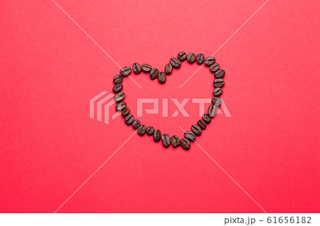 Grains of coffee in the form of heart on a red background Grains of coffee in the form of heart on a red background 61656182
