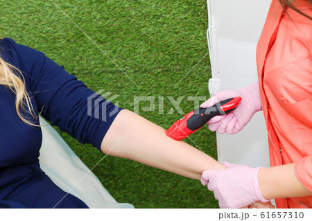 Cutting hair on the girl's hand with an electric Cutting hair on the girl's hand with an electric 61657310