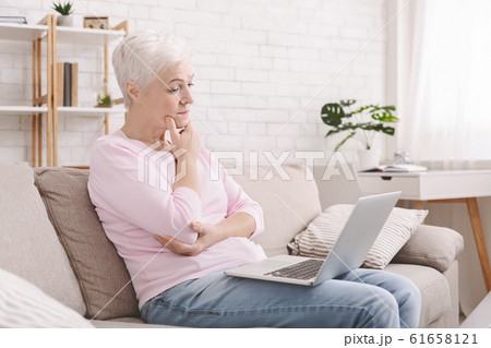 Puzzled senior lady looking at laptop with perplexity Puzzled senior lady looking at laptop with perplexity 61658121